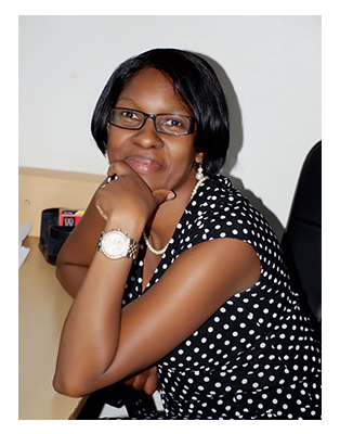 Pauline Byakika sitting at a desk