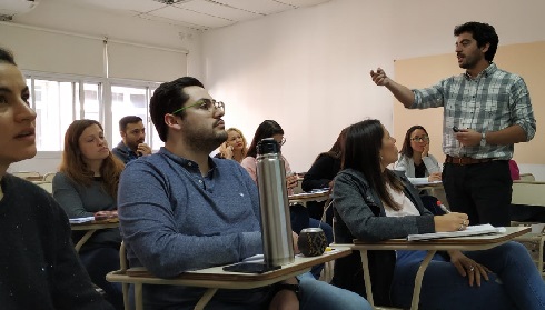 Image shows Dr Vicco standing talking to a number of participants at a workshop