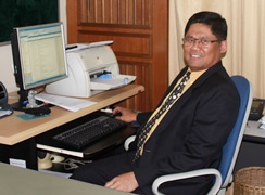 Profile photo of Leonard seated at his desk