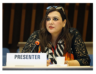 Razia sitting at a desk behind Presenter sign