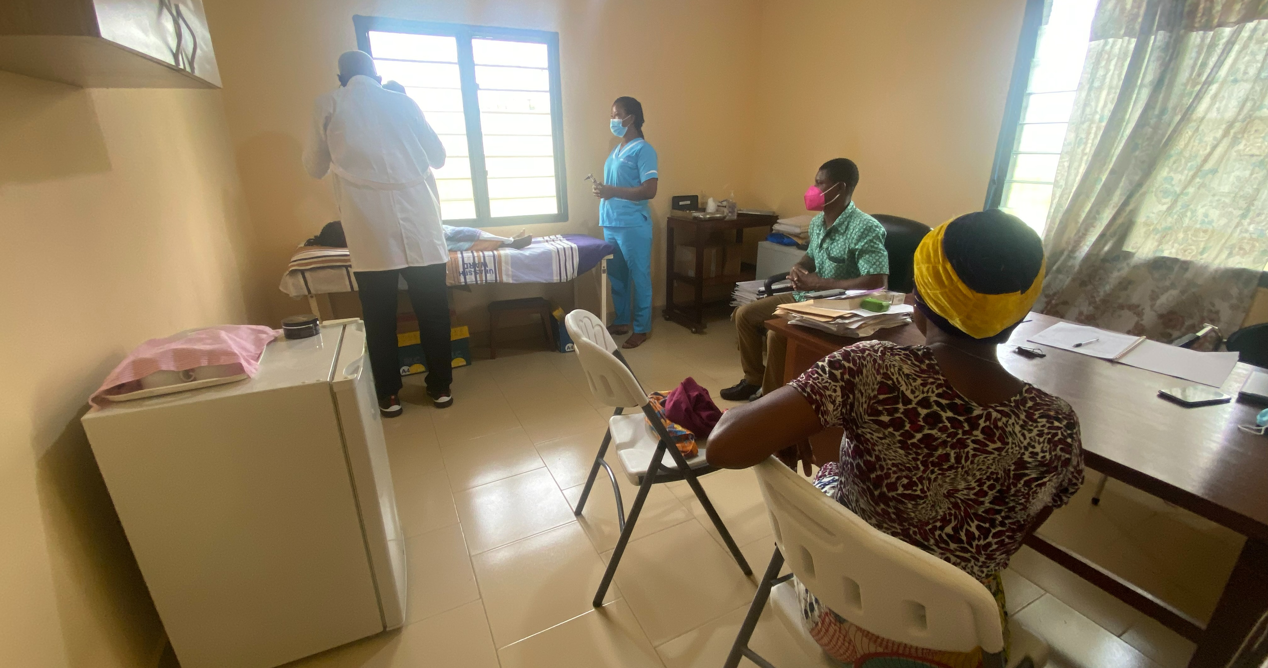 Dr Nicholas Opoku and a study nurse are examining a child in the presence of an interpreter and the mother.