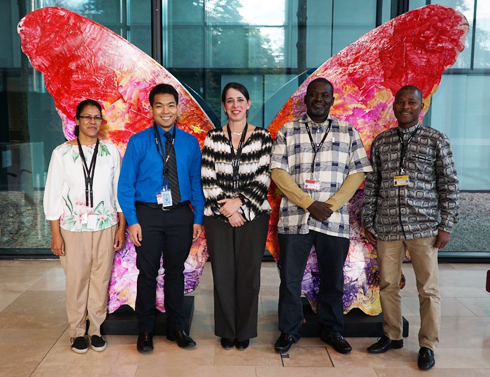 the five finalists in front of a butterfly sculture