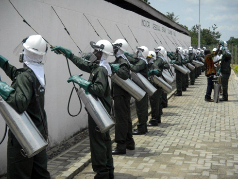 image shows several people in PPE spraying