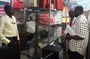 Image shows three people looking at stock on shelving