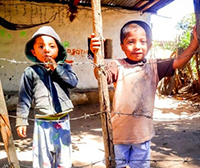 image of two young children behind a fence