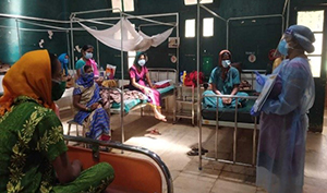 Image shows people wearing masks in a hospital ward