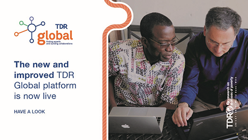 Image shows two people looking at two laptops