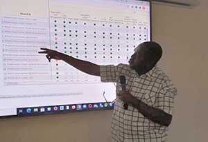Image shows a trainer pointing to a screen showing the data collection platform